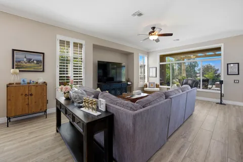 a living room with furniture kitchen view and a chandelier