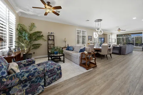 a living room with furniture kitchen view and a chandelier