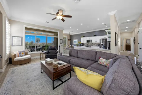 a living room with granite countertop a sink and flat screen tv