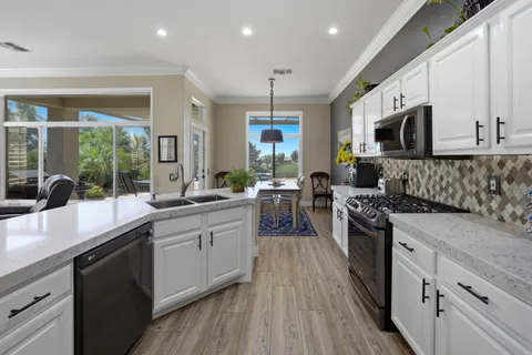 a spacious bedroom with a bed a flat screen tv and a chandelier