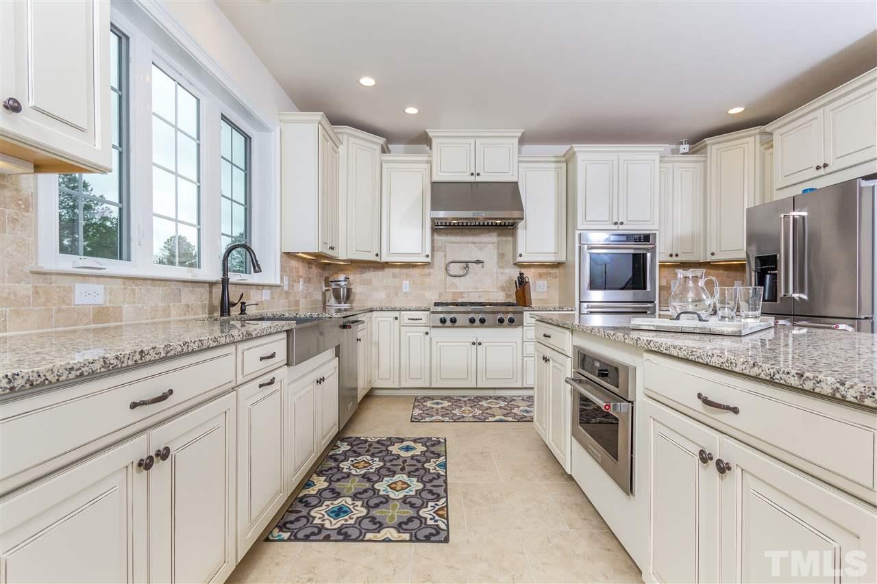 4600 Fielding Drive Raleigh, NC 27606 - Photo 5 of 25 a kitchen with kitchen island granite countertop a sink appliances cabinets and a counter top space