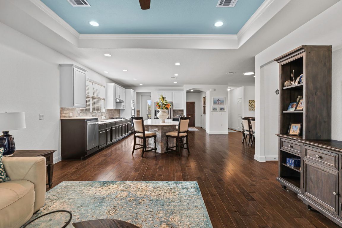 706 Kite Ridge Street Georgetown, TX 78633 - Photo 12 of 36 a living room with stainless steel appliances furniture wooden floor and a kitchen view