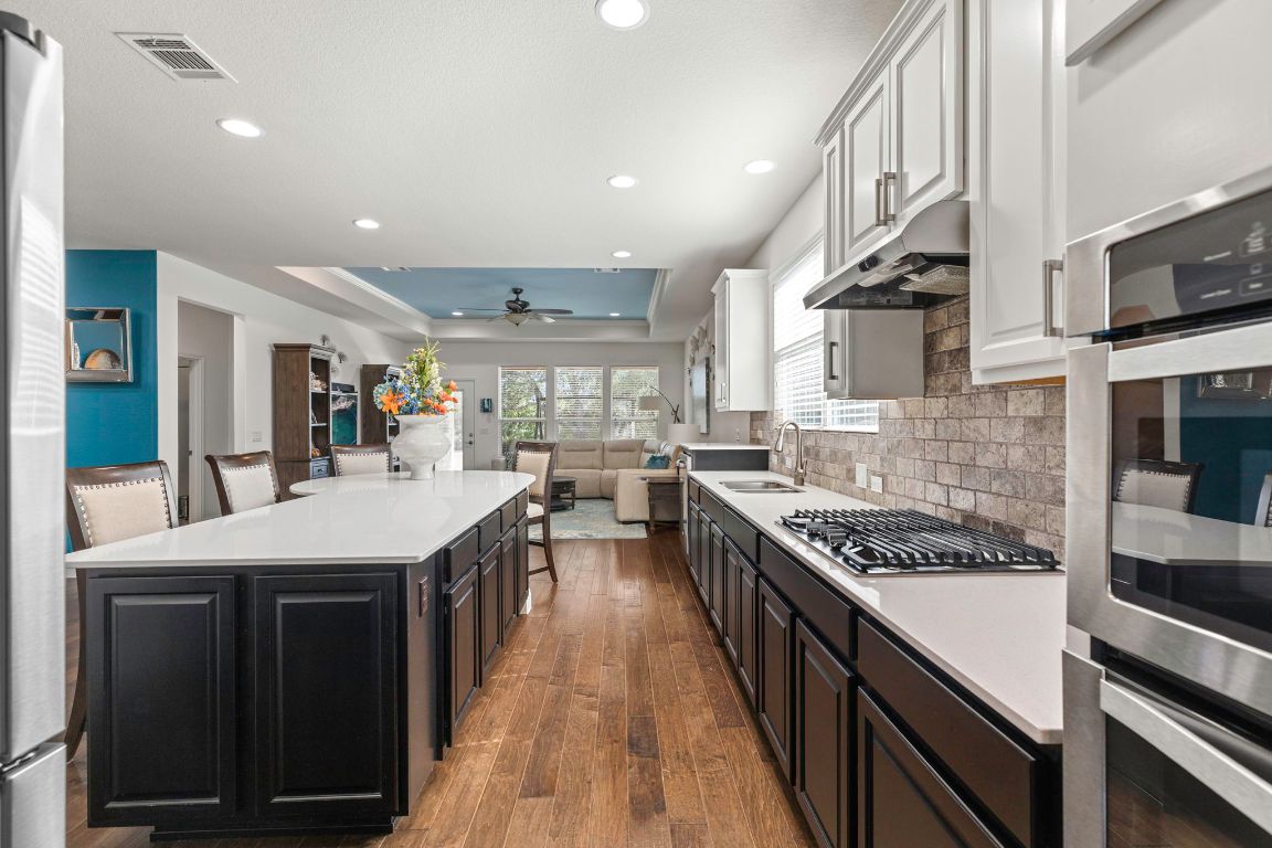 706 Kite Ridge Street Georgetown, TX 78633 - Photo 35 of 36 a kitchen with stainless steel appliances a sink stove and cabinets