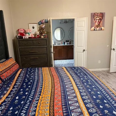 a bed sitting in a bedroom and dresser with mirror