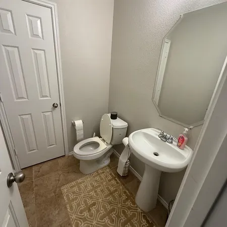a bathroom with a toilet sink and mirror