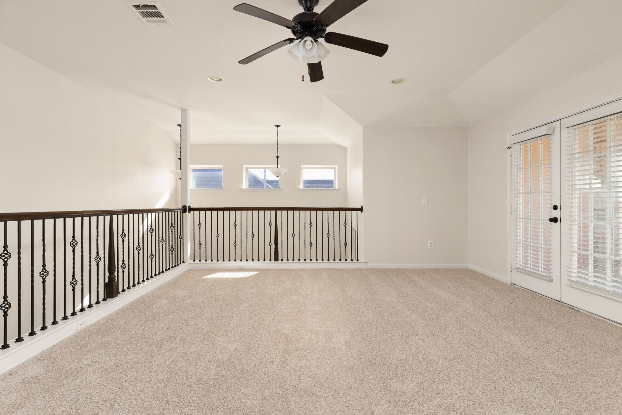 2400 Leonards Pass Leander, TX 78641 - Photo 22 of 40 An airy loft area features a ceiling fan, plush carpeting, and direct access to an outdoor space.