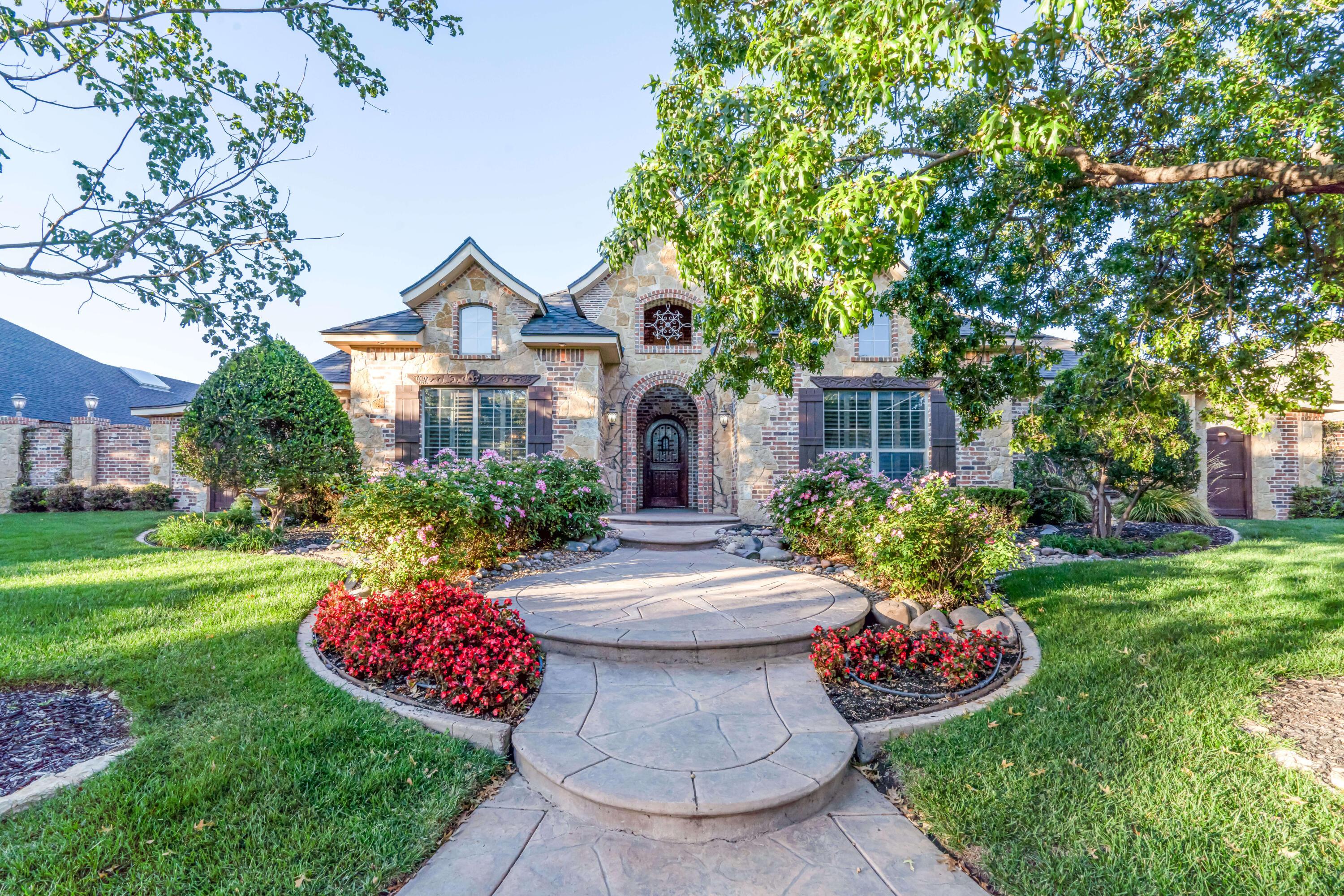 7606 Bayswater Road Amarillo, TX 79119 - Photo 1 of 65 a front view of a house with a garden and trees