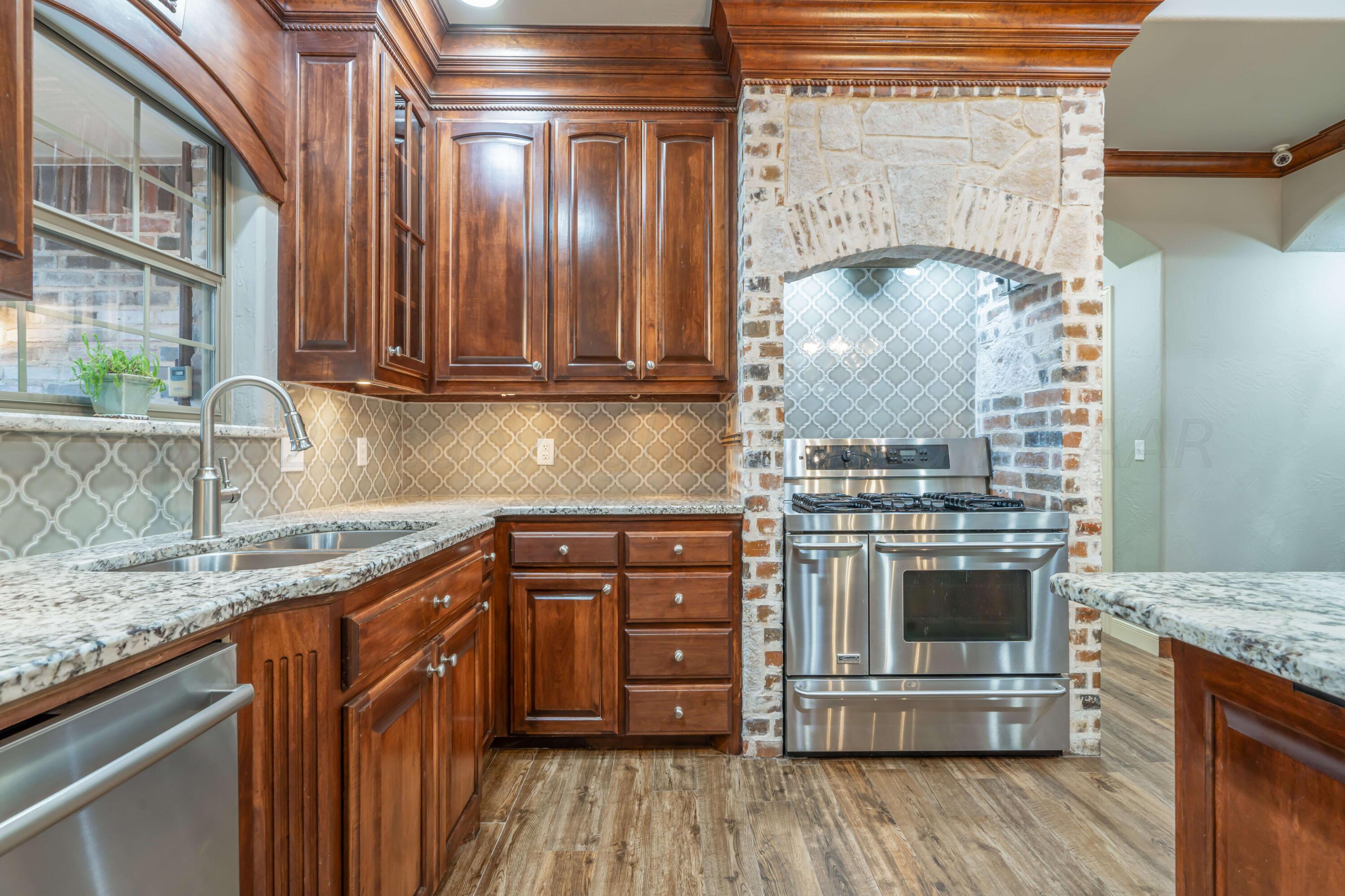 7606 Bayswater Road Amarillo, TX 79119 - Photo 34 of 65 a kitchen with stainless steel appliances granite countertop a stove a sink and a microwave