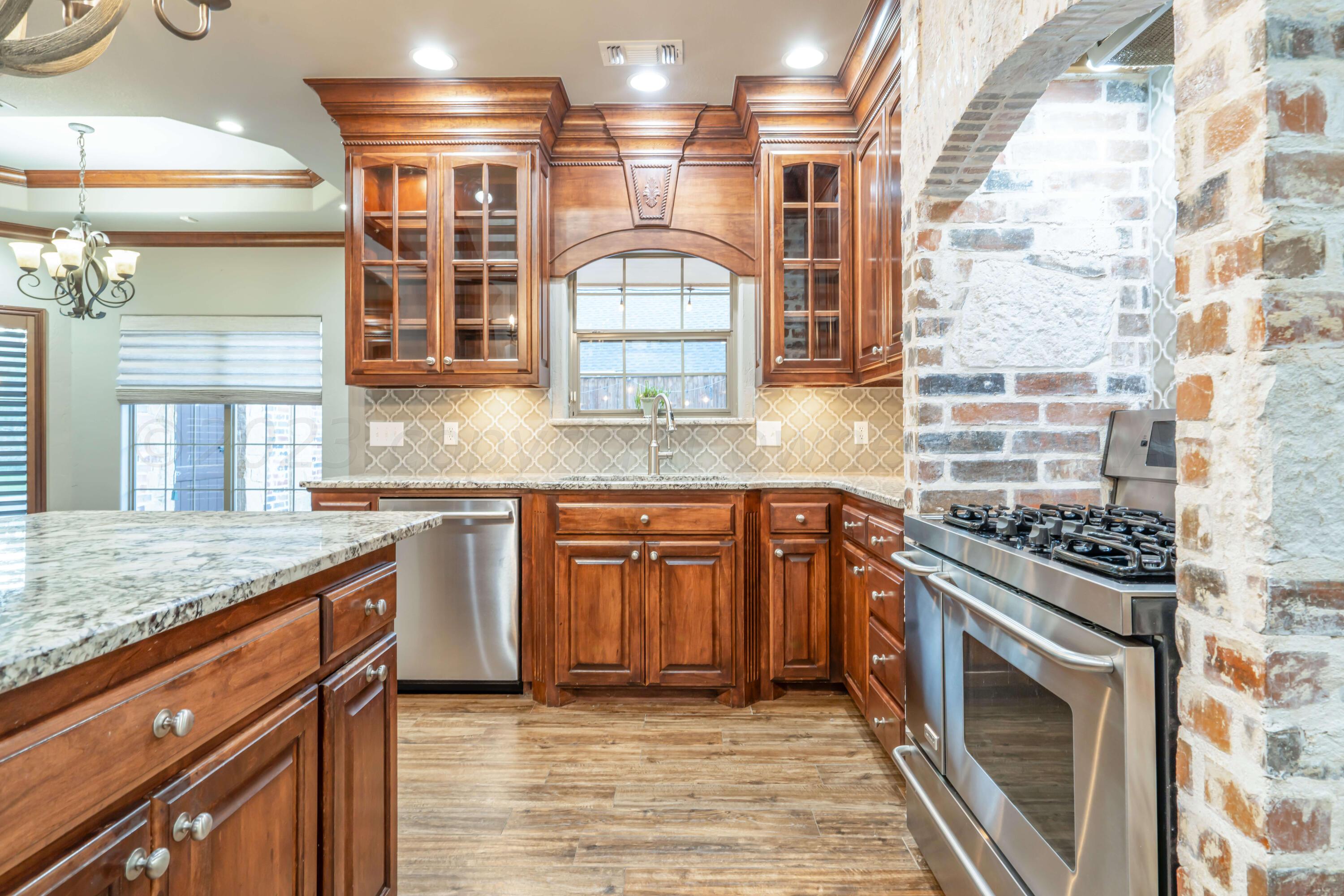 7606 Bayswater Road Amarillo, TX 79119 - Photo 35 of 65 a kitchen with stainless steel appliances granite countertop a stove and a sink