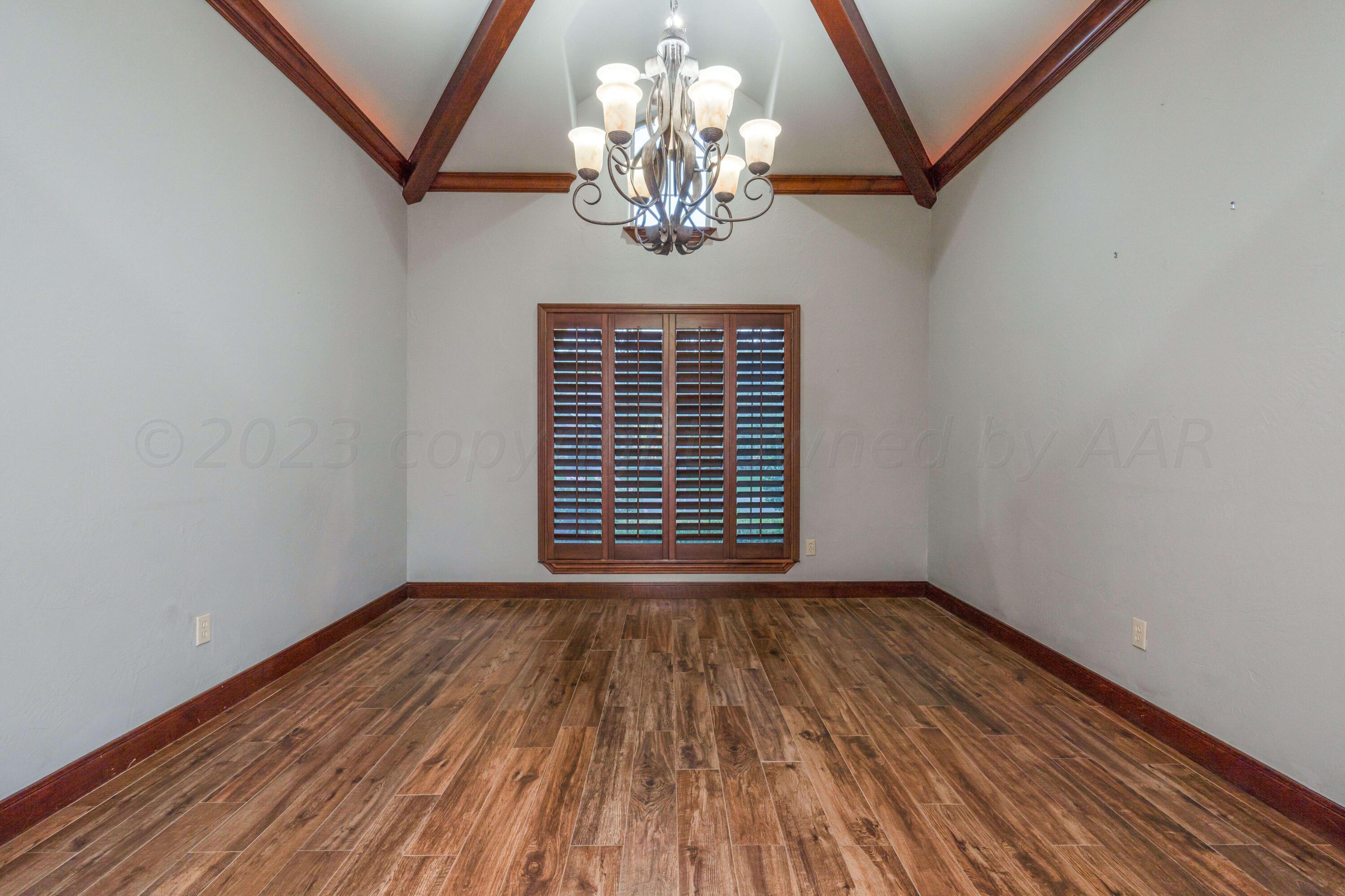 7606 Bayswater Road Amarillo, TX 79119 - Photo 39 of 65 a view of an empty room with wooden floor and a window