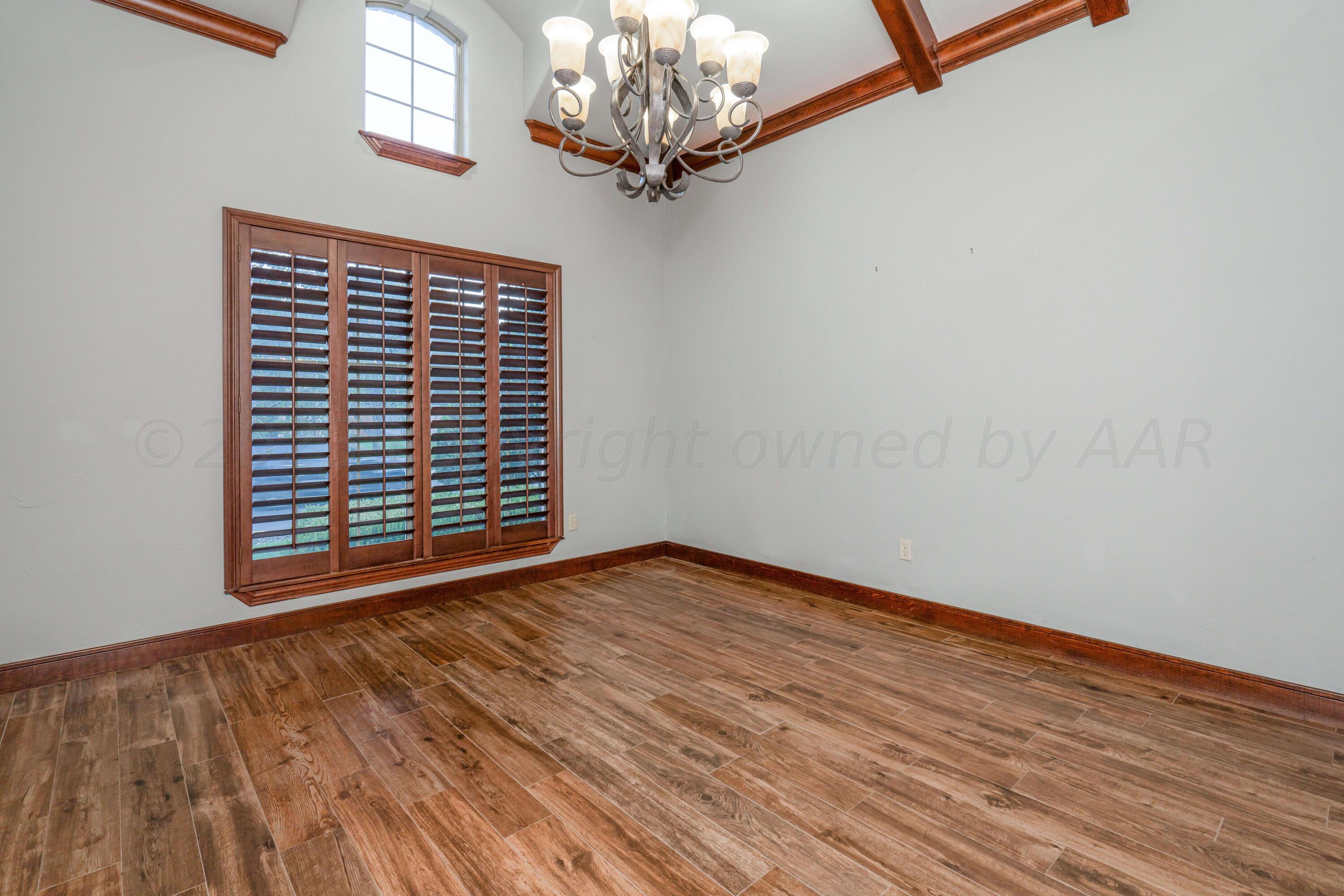 7606 Bayswater Road Amarillo, TX 79119 - Photo 40 of 65 a view of an empty room with wooden floor and a window