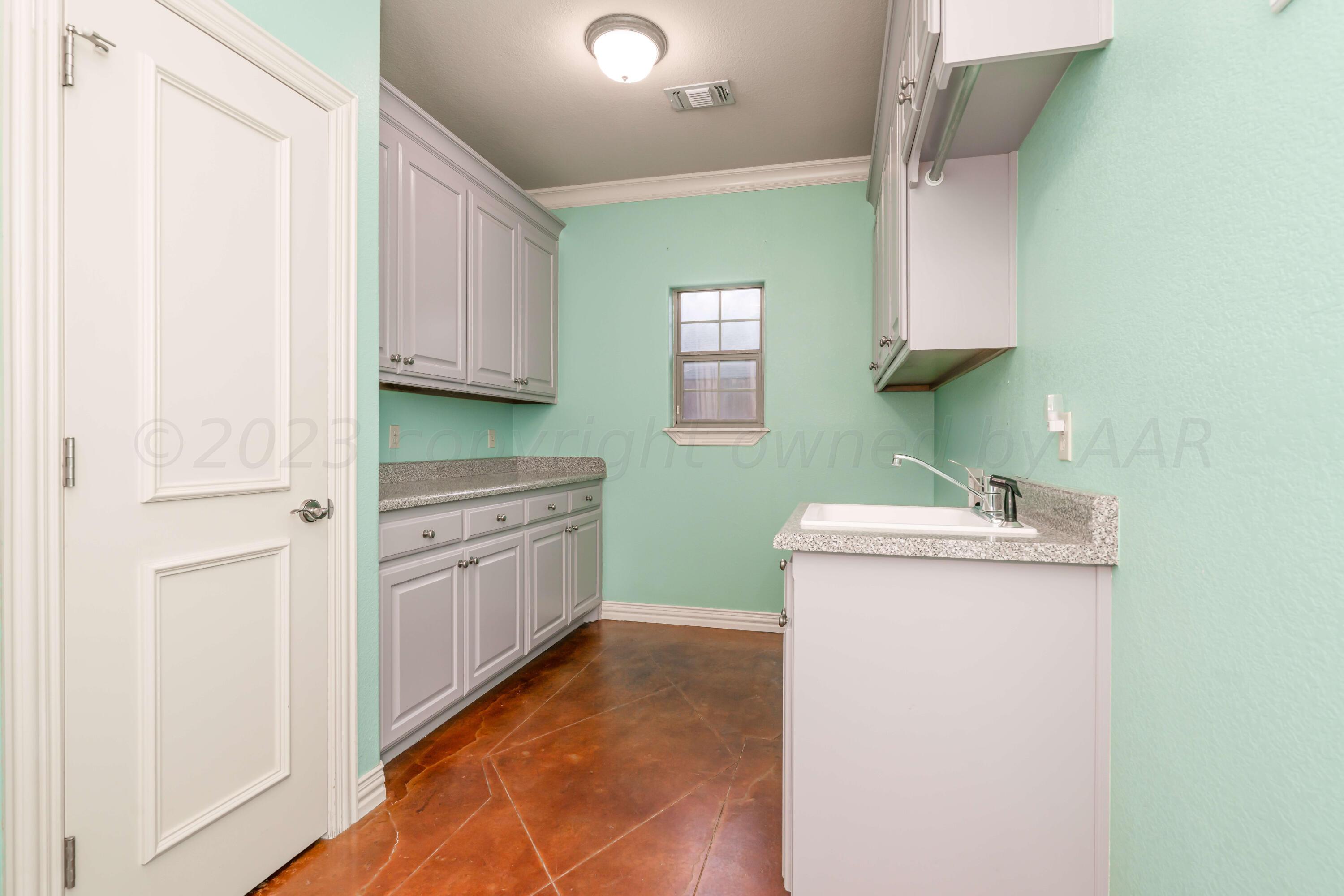 7606 Bayswater Road Amarillo, TX 79119 - Photo 43 of 65 a kitchen with a sink a stove and cabinets
