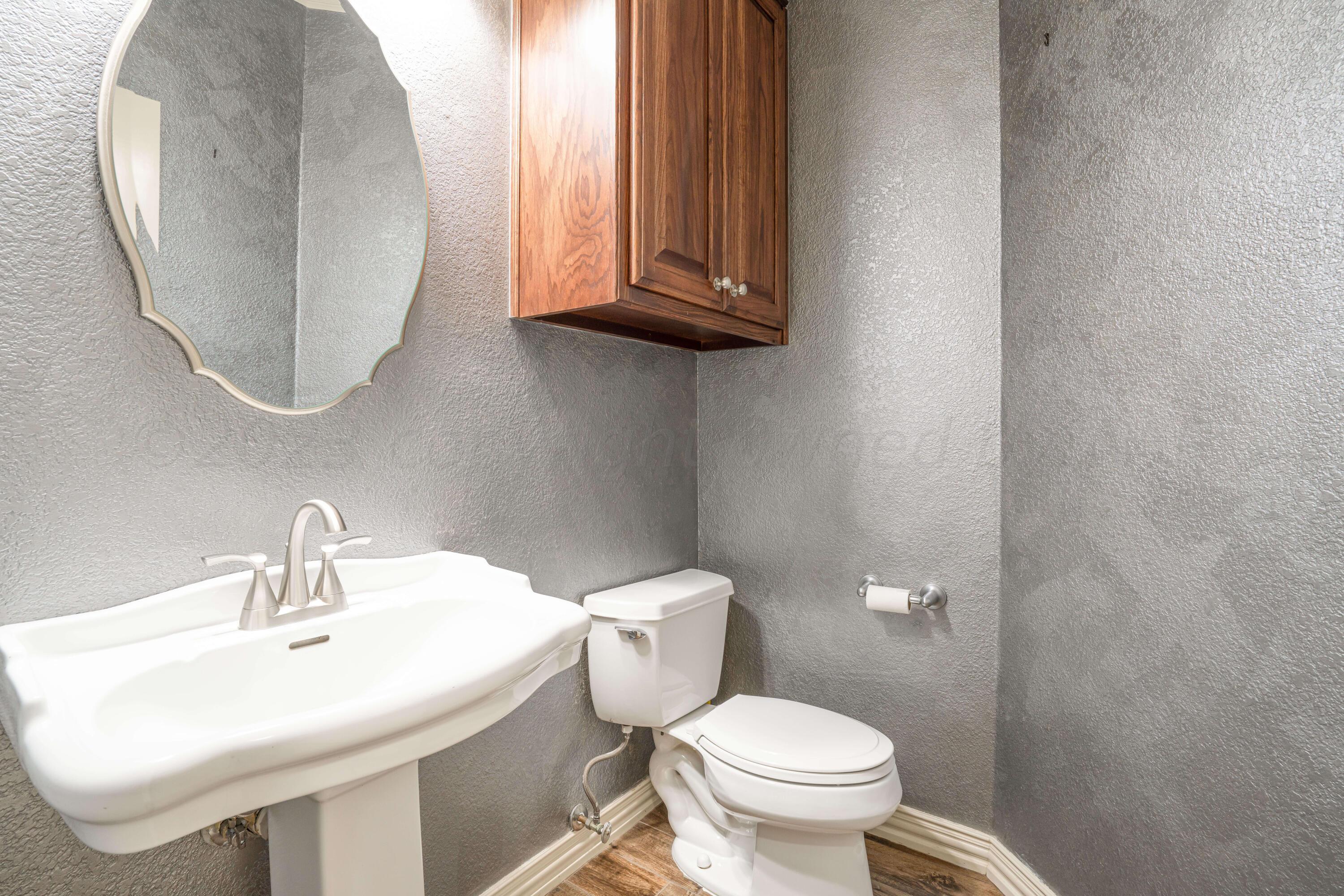 7606 Bayswater Road Amarillo, TX 79119 - Photo 44 of 65 a bathroom with a toilet sink and mirror