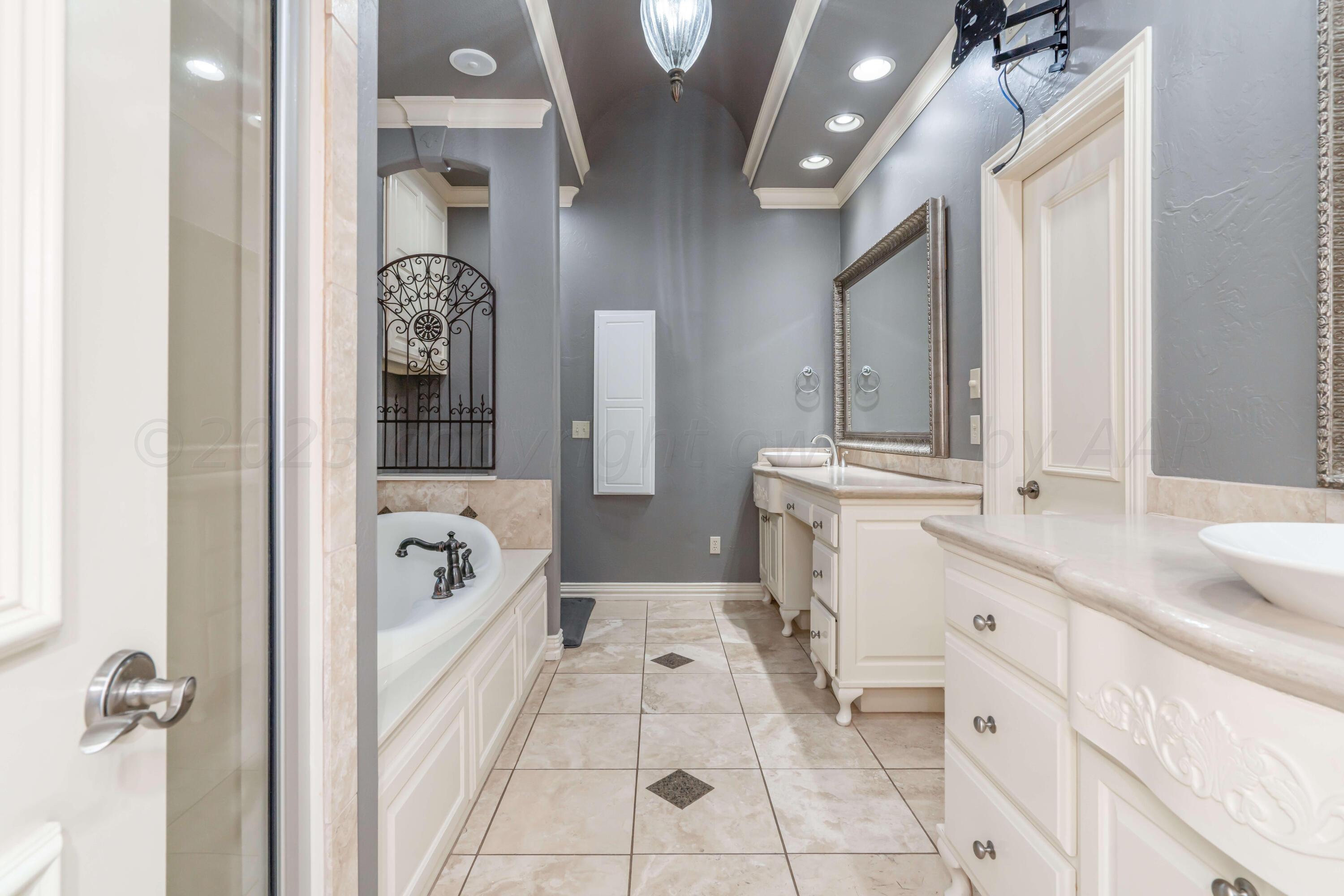 7606 Bayswater Road Amarillo, TX 79119 - Photo 47 of 65 a spacious bathroom with a tub sink and mirror