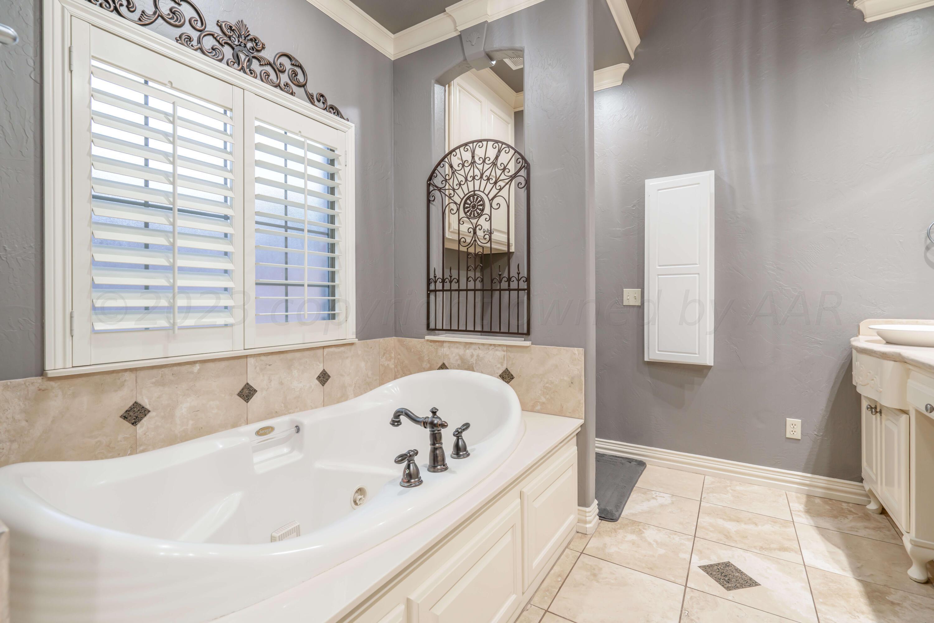 7606 Bayswater Road Amarillo, TX 79119 - Photo 49 of 65 a bath tub sitting in a bathroom next to a window