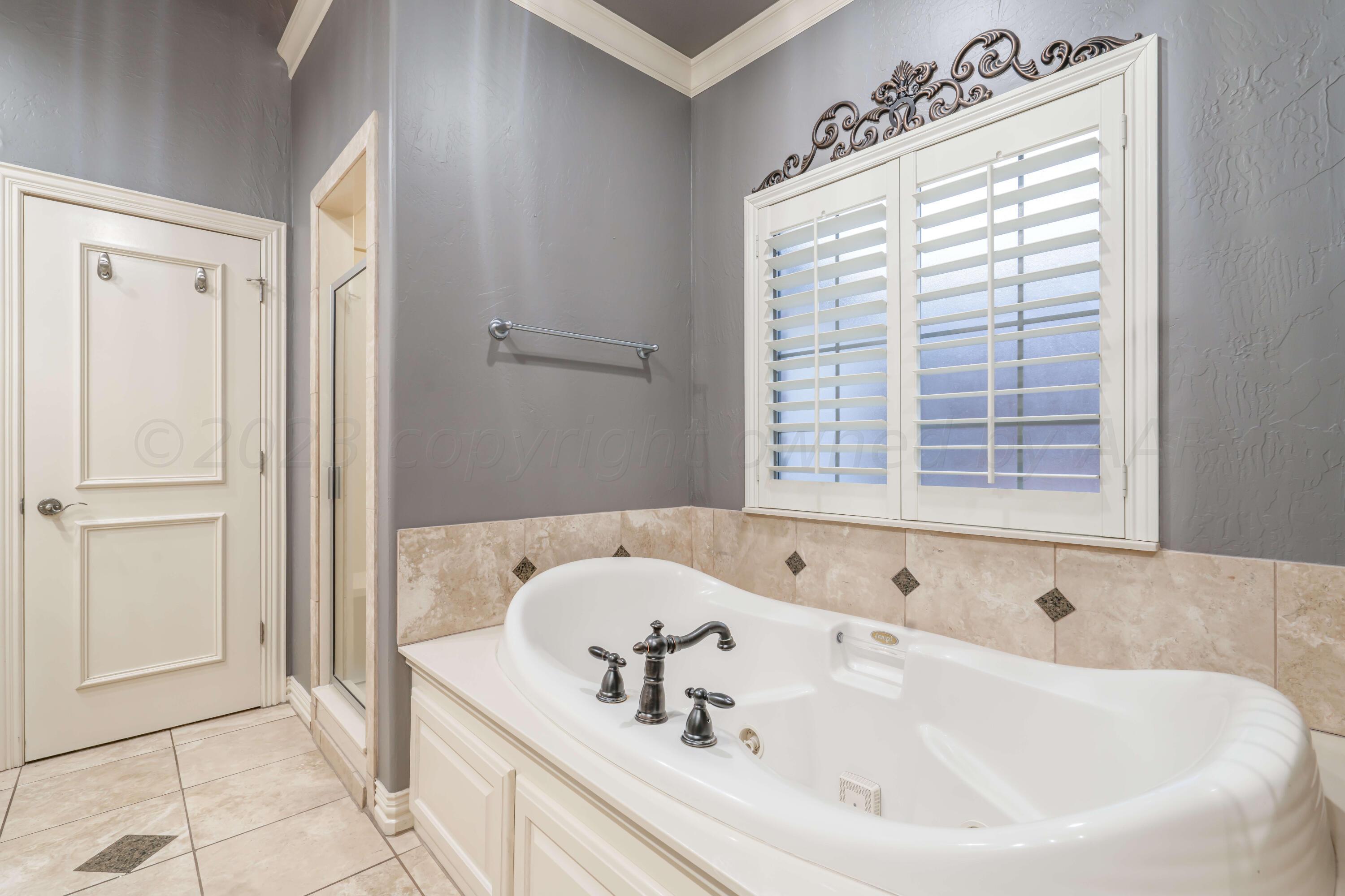 7606 Bayswater Road Amarillo, TX 79119 - Photo 50 of 65 a white bath tub sitting in a bathroom next to a window