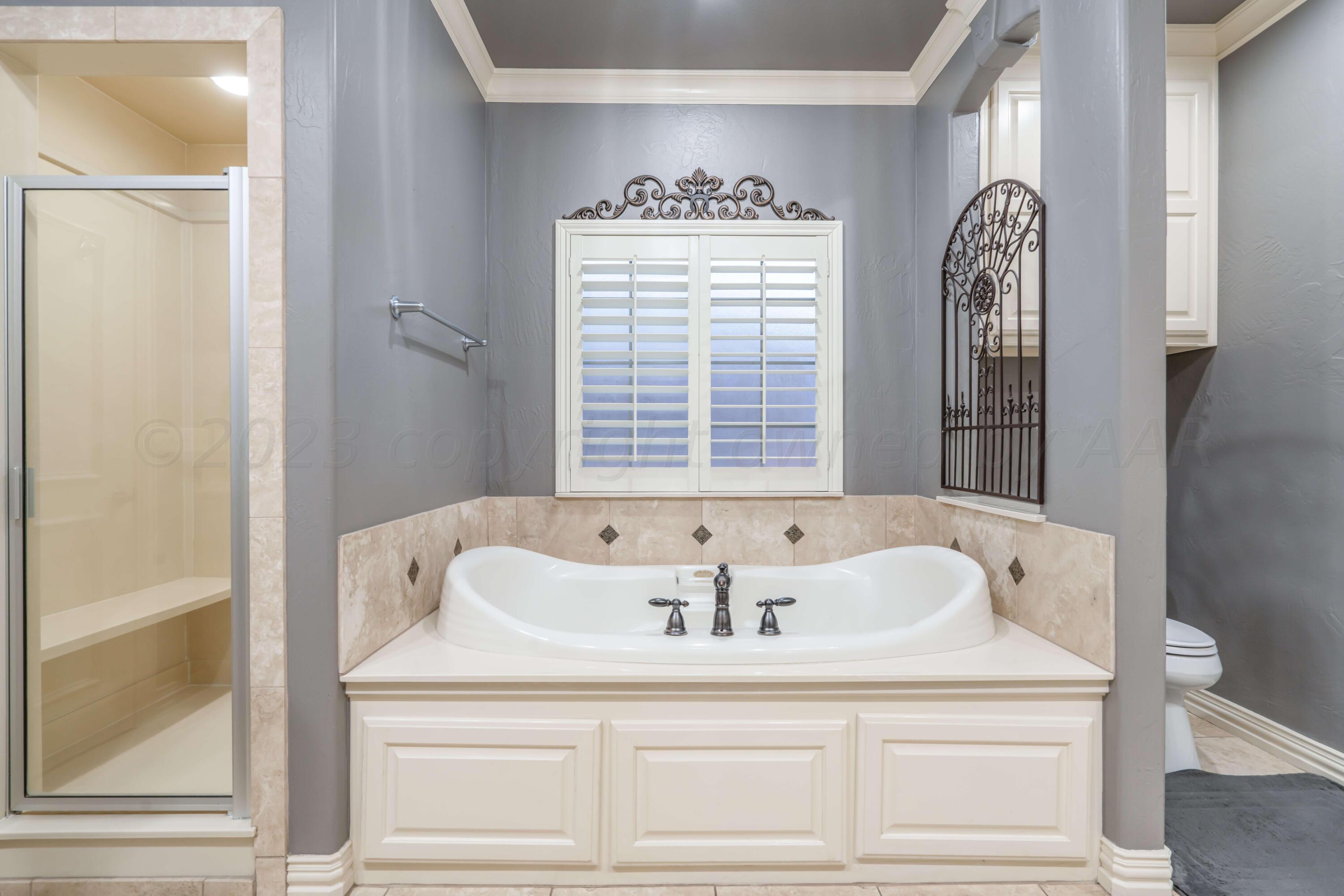 7606 Bayswater Road Amarillo, TX 79119 - Photo 51 of 65 a bathroom with a bathtub and a window
