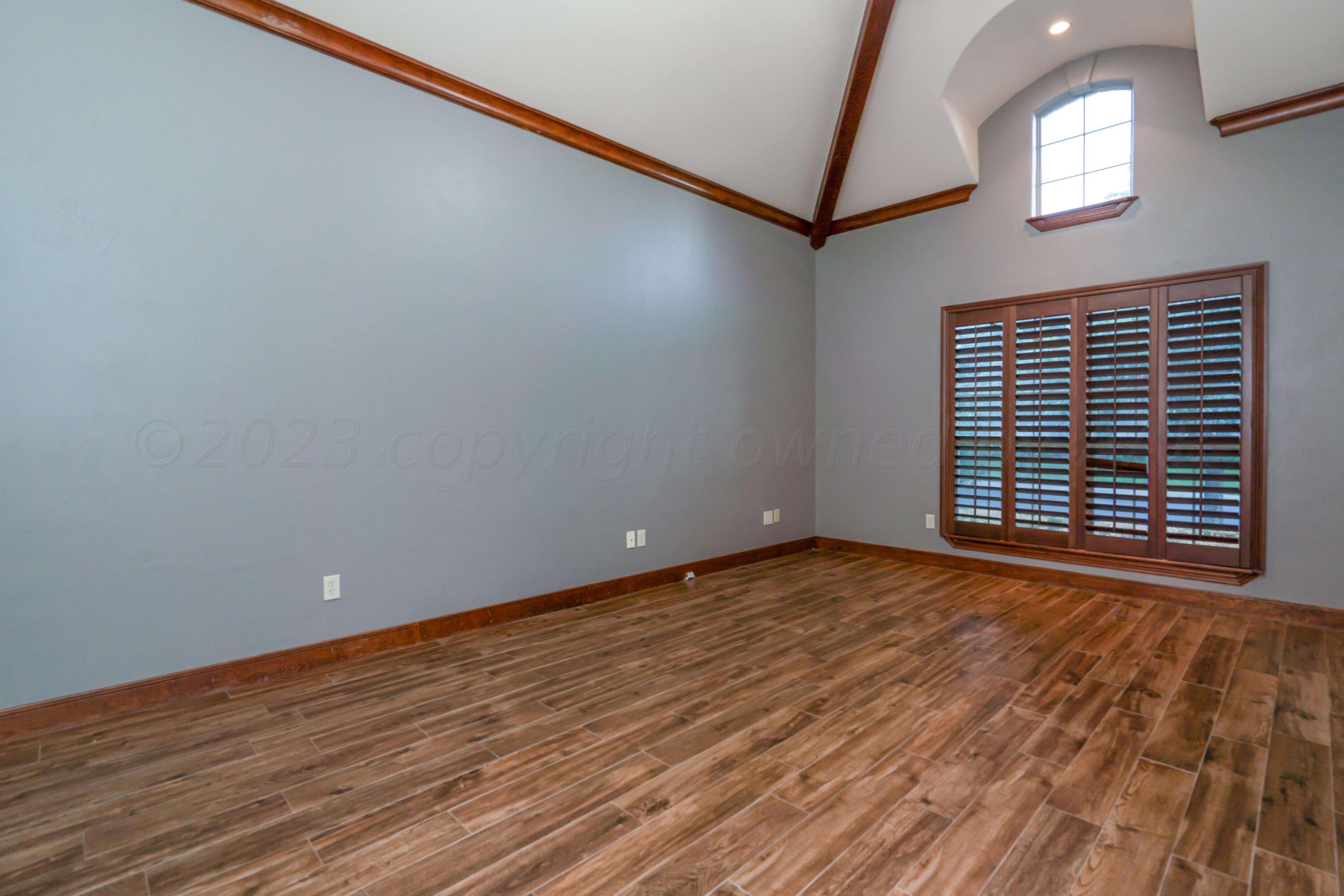 7606 Bayswater Road Amarillo, TX 79119 - Photo 55 of 65 a view of an empty room with wooden floor and a window