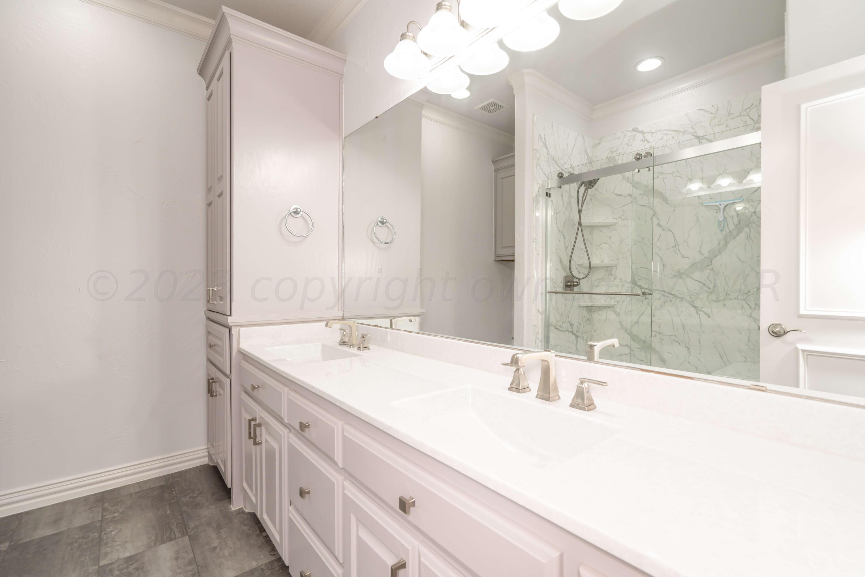 7606 Bayswater Road Amarillo, TX 79119 - Photo 58 of 65 a bathroom with a double vanity sink mirror and shower