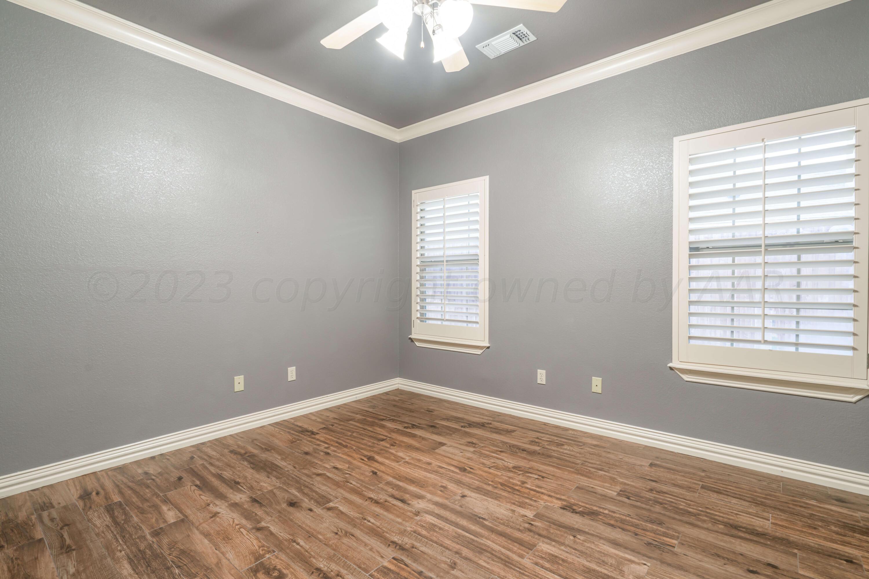 7606 Bayswater Road Amarillo, TX 79119 - Photo 62 of 65 an empty room with wooden floor and windows