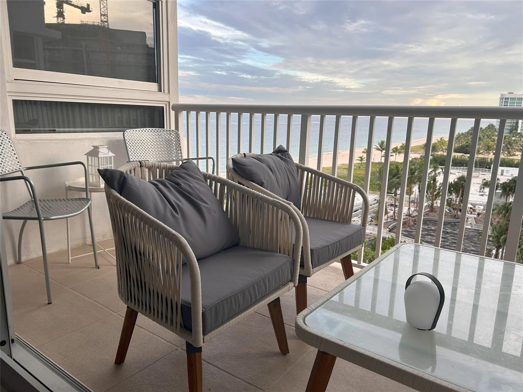 a balcony with two chairs and a potted plant