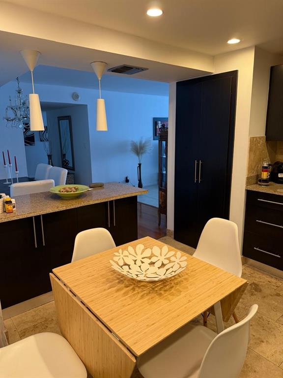 1370 South Ocean Boulevard, Unit 902 Pompano Beach, FL 33062 - Photo 11 of 21 a dining room with a table chairs and kitchen view