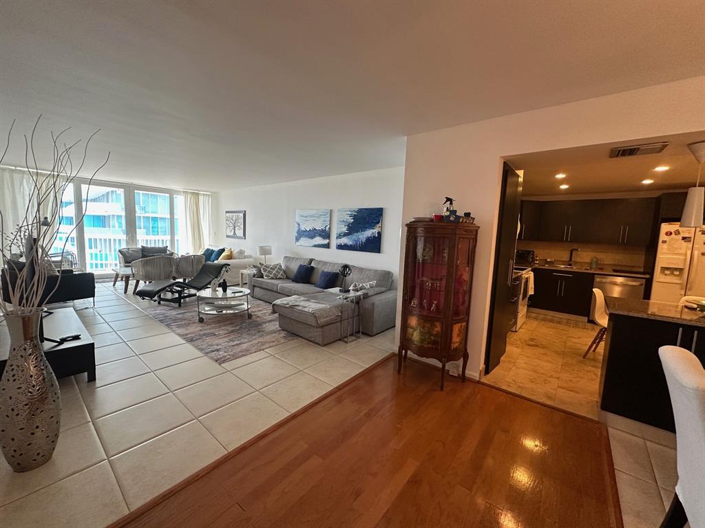 1370 South Ocean Boulevard, Unit 902 Pompano Beach, FL 33062 - Photo 13 of 21 a living room with furniture a flat screen tv and a large window