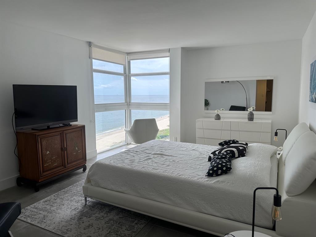 1370 South Ocean Boulevard, Unit 902 Pompano Beach, FL 33062 - Photo 3 of 21 a bedroom with a bed and a flat screen tv