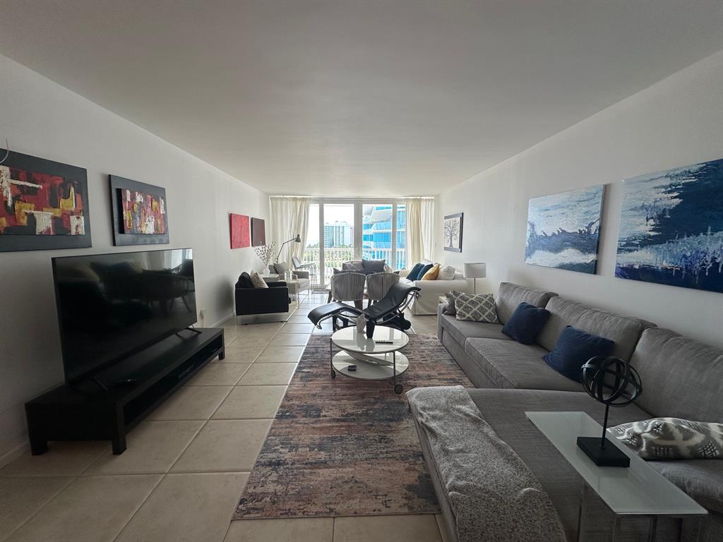 1370 South Ocean Boulevard, Unit 902 Pompano Beach, FL 33062 - Photo 6 of 21 a living room with furniture and a flat screen tv