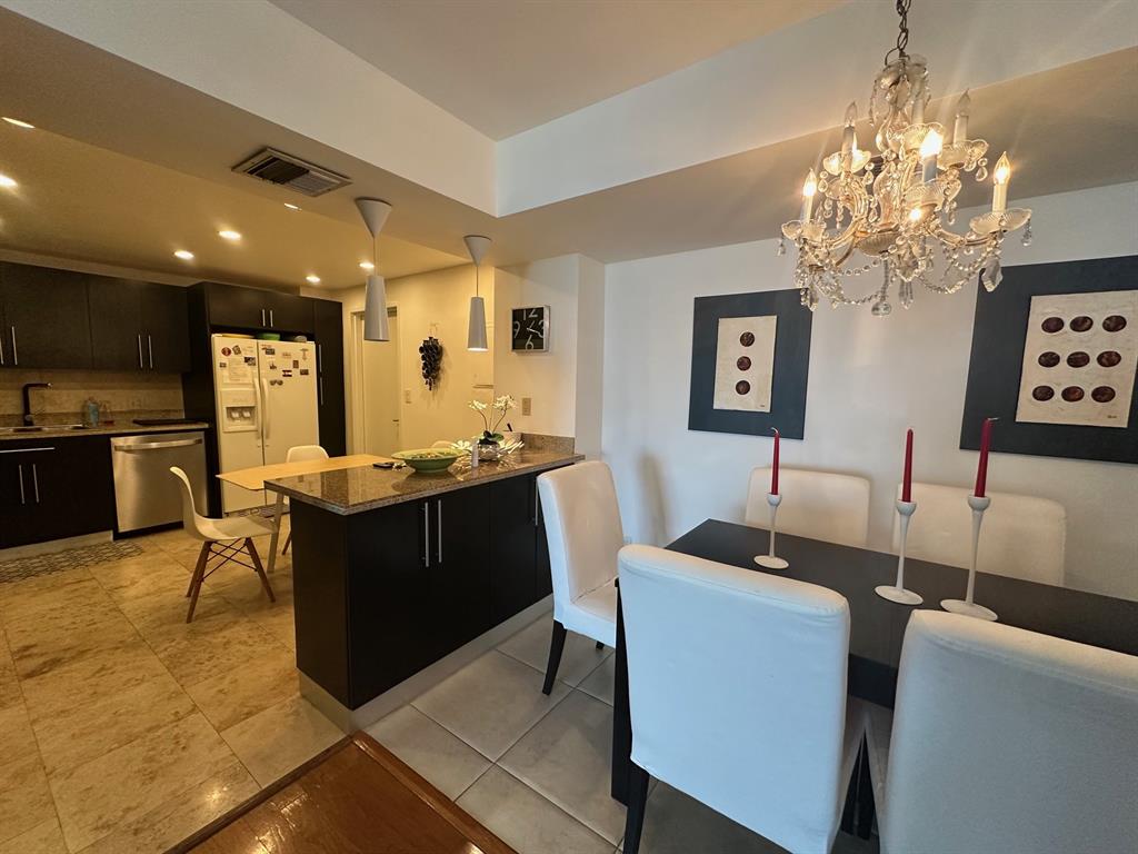 1370 South Ocean Boulevard, Unit 902 Pompano Beach, FL 33062 - Photo 9 of 21 a kitchen with cabinets a counter space dining table and a sink