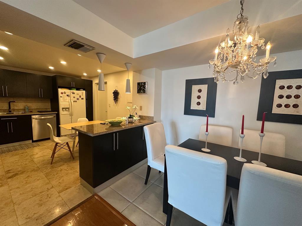 1370 South Ocean Boulevard, Unit 902 Pompano Beach, FL 33062 - Photo 10 of 21 a kitchen with cabinets a counter space dining table and stainless steel appliances