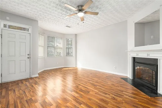 a view of empty room with fireplace and wooden floor