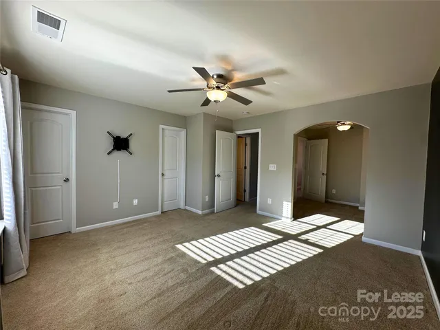 a view of an empty room with a ceiling fan