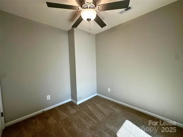 an empty room with a ceiling fan and fan