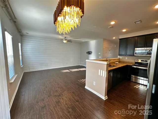 a kitchen with stainless steel appliances granite countertop a stove a sink and a microwave