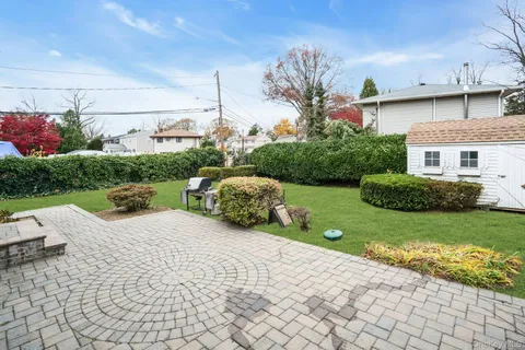a view of a white house with a yard and potted plants