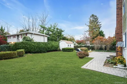 a view of a house with large windows and a small yard