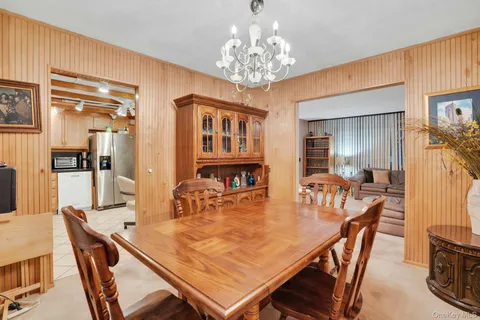 a dining room with furniture a chandelier and wooden floor