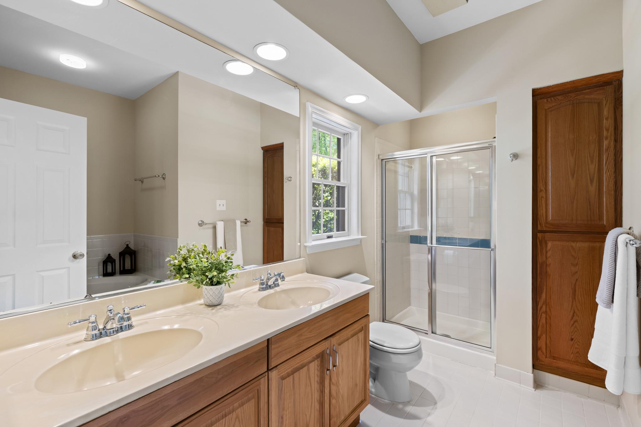 2702 Summerview Way, Unit 103 Annapolis, MD 21401 - Photo 9 of 18 a bathroom with a double vanity sink toilet and shower