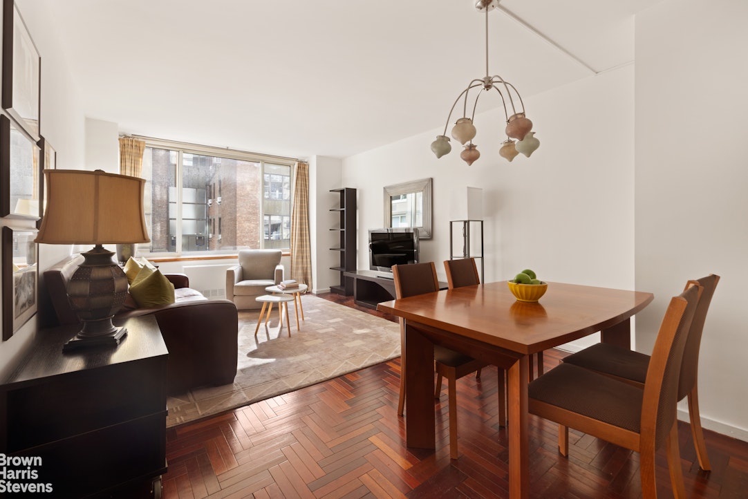 a living room with furniture dining table and a chandelier