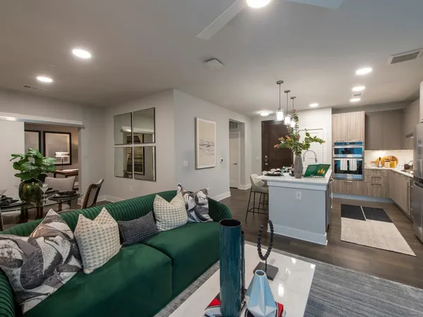 a living room with furniture and kitchen view
