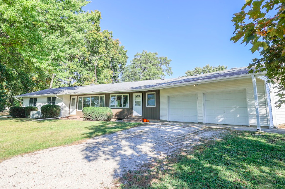 a front view of house with yard and trees around