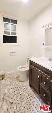 a bathroom with a sink a toilet and mirror