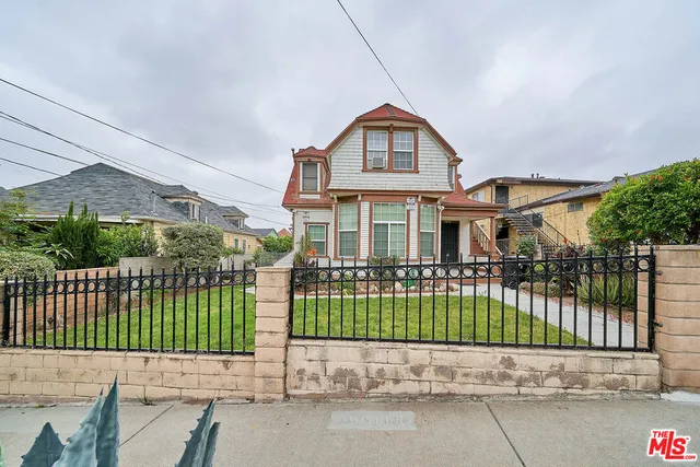 a front view of a house with a garden