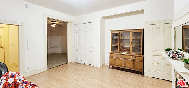 a view of a bedroom with wooden floor and closet