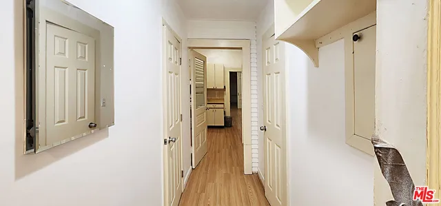 a view of a hallway with wooden floor and staircase