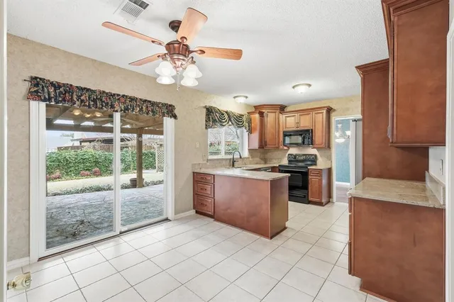 a large kitchen with granite countertop a large counter top space appliances and cabinets