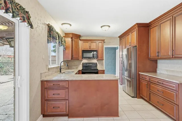 a kitchen with stainless steel appliances granite countertop a refrigerator and a stove top oven