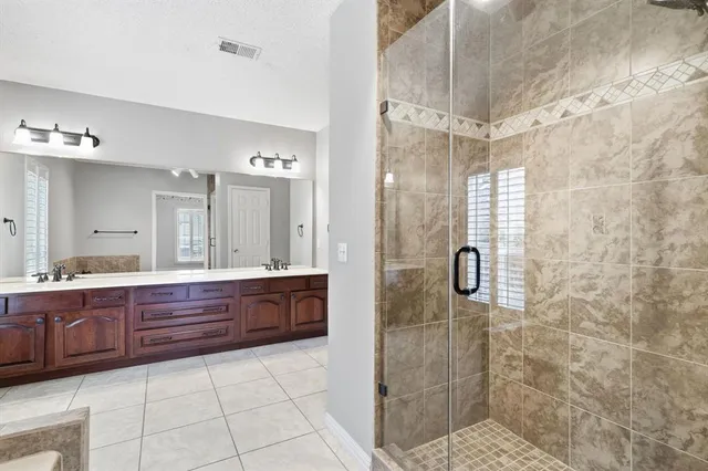 a bathroom with a granite countertop sink mirror and shower