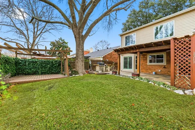 a view of a house with backyard and a tree